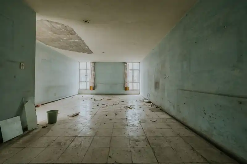 Water-damaged room with a collapsed ceiling patch and wet floor